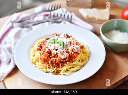 Repas délicieux plats de pâtes, spaghettis à la bolognaise sur une plaque blanche. Plat de pâtes, cuisine italienne traditionnelle avec le parmesan, les viandes hachées et feuille de basilic. Banque D'Images