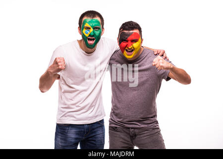 Les fans de football supporters avec visage peint d'équipes nationales du Brésil et de l'Allemagne isolated on white Banque D'Images