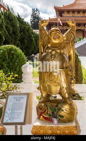 Hacienda Heights, Californie, USA - Le 23 mars 2018 : statue en or du Bouddha Maitréya à Hsi Lai Temple bouddhiste sur le côté de la jardin verdoyant. Partie de temple vi Banque D'Images