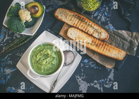 Soupe crème de brocoli, chou-fleur à l'avocat et de crème fouettée sur une table en bois. La vue du sommet. Banque D'Images