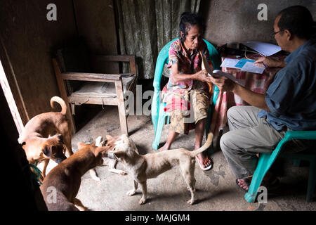 Le Père Antonio Martins, Abad-Santos un médecin/jésuite connu comme le père Bong, gère une clinique mobile dans les terrains montagneux du Timor-Leste. Le manque de moyens de transport et des conditions d'isolement, il est difficile pour les populations rurales, de recevoir des soins de santé adéquats. Fr Bong voyage avec deux assistants pour zones isolées dans les districts d'Ermera et Liquica. Père Bong consulte un patient dans l'Naisuta hameau, district d'Ermera. Banque D'Images