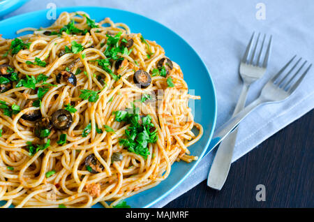 Spaghetti alla Puttanesca - pâtes italiennes traditionnelles aux olives noires, Thon, anchois, les câpres et le persil. La nourriture végétarienne. La cuisine italienne. Banque D'Images