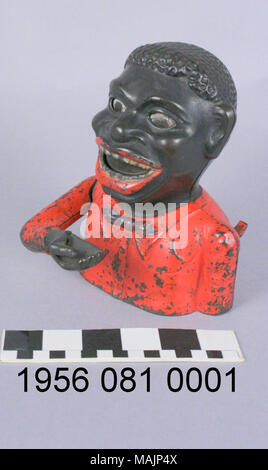 Banque mécanique en fonte en forme de buste d'un homme portant une chemise rouge et cravate noire. Pour l'exploitation de la banque, une pièce est placée dans la main de la figure et d'un levier actionné causant la figure pour rouler des yeux comme les dépôts à la main la pièce dans la figure. Fabriqué par l'entreprise de matériel vers 1883 Shepard. Titre : African American Caricature pièce mécanique Banque . vers 1883. Shepard entreprise de matériel Banque D'Images