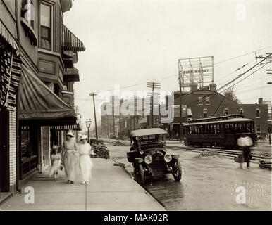 Vue vers l'est sur le Boulevard de Delmar Kingshighway Boulevard. Deux femmes et une jeune fille sont représentés devant une vitrine de magasin. La construction sur la rue ou sur les voies de tramway est en cours sur la photographie. Titre : Vue vers l'est sur le Boulevard de Delmar Kingshighway Boulevard. . Vers 1914. W.C. Personnes Banque D'Images