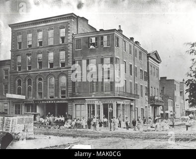 Angle sud-est de la 7e Rue et de la rue d'olive. Le bâtiment avec des gens sur le balcon est le Fire House of Missouri # 5 incendies volontaires Co. sur le côté est de la septième entre oliviers et pins. Joyeux et Glenny Grocers est photographié à 92 Rue d'olive. Avant le premier service d'incendie en 1857, la lutte contre l'incendie tous à St Louis a été fait par volunteer fire maisons situées dans toute la ville. Le Missouri # 5 Incendie volontaire exploité de 1839 à 1858 avec la devise "ǣPress sur.  ? Pendant le grand incendie de 1849, le capitaine Thomas B. Targee du Missouri n° 5 est mort tout en répartissant la puissance explosive Banque D'Images