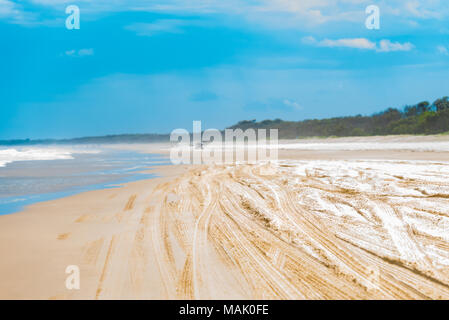 Vue sur la plage de flou artistique avec les traces de pneus et 4x4 à l'horizon. Image vacances à l'espace réservé au texte Banque D'Images