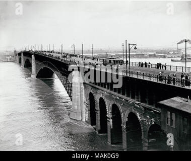 L'horizontale, 1970 Photographie noir et blanc montrant le pont d'Eads au cours de l'eau élevée en 1903. Les travées du centre de l'image. Les piétons peuvent traverser le pont et de peering sur le bord sur le fleuve Mississippi. Un tramway traverse le pont près du centre de l'image, et plusieurs petites voitures ou wagons sont derrière elle. Titre : le trafic piétonnier et le chariot sur EADS Bridge pendant les inondations de 1903. . 1903. Banque D'Images