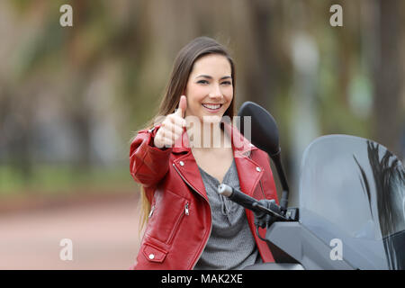 Motards heureux assis sur un vélo looking at camera with Thumbs up Banque D'Images