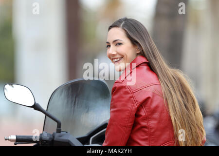 Portrait of a happy biker vous regarde sur une moto dans la rue Banque D'Images