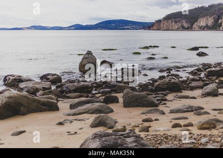 Plage déserte à Hobart, Tasmanie avec des pierres au premier plan sur l'image avec des tons doux légèrement Banque D'Images