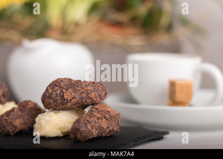 Des variété de truffes au chocolat sur une plaque avec du café. Banque D'Images