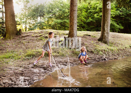 Les petites filles debout dans le lac. L'été ensoleillé. Banque D'Images