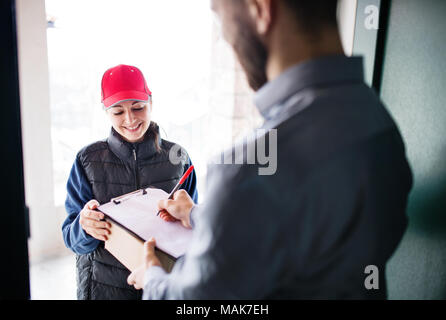 Réception de colis un homme femme livraison à la porte. Banque D'Images