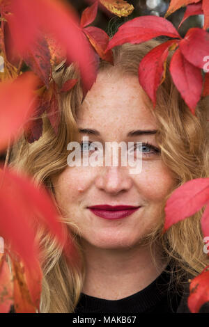 Belle femme blonde en feuilles des raisins Banque D'Images