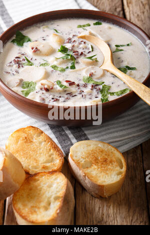 Soupe de riz sauvage aux cèpes et légumes close-up dans un bol et des tartines sur la table verticale. Banque D'Images