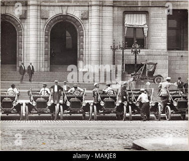 L'horizontale, 1970 Photographie noir et blanc montrant une rangée de six Model T Ford garée en face de l'Hôtel de Ville de Saint-Louis, probablement près de l'intersection de 12th Street, maintenant Tucker Boulevard, et Walnut Street . Les hommes sont assis dans le siège du conducteur, de quatre des voitures, et un homme grimpe dans ou hors d'une cinquième voiture. D'autres hommes peut être vu marcher sur le trottoir à l'arrière-plan. Une note dactylographiée sur le verso de l'impression, peut-être une pièce légende, se lit comme suit : "modèle T Ford, ca. 1909. Quatorze de ces voitures ont été achetés par l'Hôtel de Ville. Les voitures avaient un moteur 4 cylindres et 2 vitesses, caractéristiques qui Banque D'Images