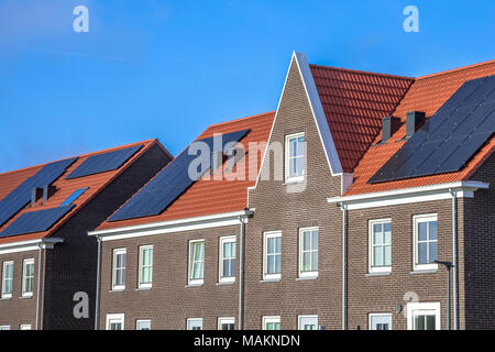 Close up de rangées de maisons modernes avec des panneaux solaires, brown briques et toits de tuiles rouges de style néoclassique à groningen Pays-Bas Banque D'Images