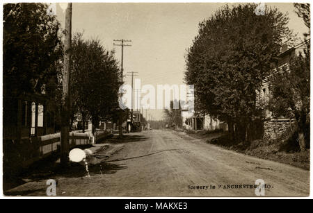 L'horizontale, noir et blanc Carte postale montrant une vue photographique à la recherche vers le bas une route de terre dans la région de Manchester, Missouri. Les maisons peuvent être vue à travers les arbres sur les deux côtés de la route. Plusieurs de ces chantiers sont bordés par des piquets de clôtures et poteaux de la ligne de rue sur la gauche. Une légende le long du bord inférieur se lit comme suit : 'Scenery à Manchester, MO.' sur l'arrière de la carte postale, il y a une note écrite au crayon de M. McLahill à Mme Thomas Toy Joy ou discuter M's séjour à Manchester. La carte postale a été oblitérée à Chesterfield, Missouri le 12 août 1911. Titre : 'Scenery à Manchester, Mo.' . 1 Banque D'Images