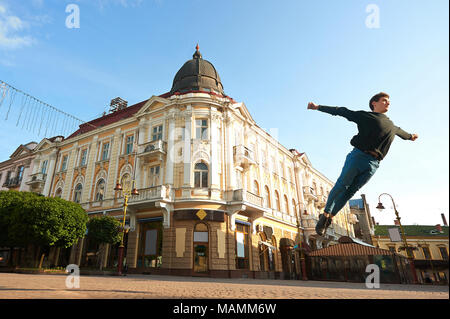 Ivano-Frankivsk, Ukraine - 1 juin 2015 : jeune garçon danse fait des pirouettes sur le matin dans les rues de la ville. Il y a bel et authentique de facad vieux bâtiment derrière lui. vieux architeckture. Banque D'Images