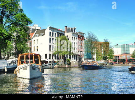 Canal ou gracht à Amsterdam City. Scène de rivière Amstel avec des bateaux et des maisons anciennes. Banque D'Images