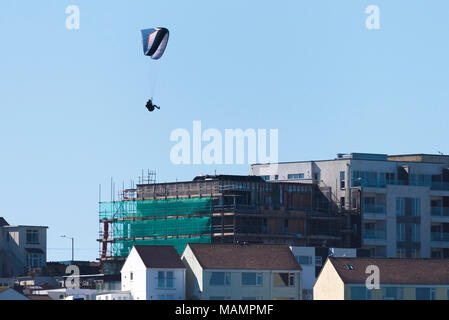 Un parapente voler au-dessus de bâtiments à Newquay Cornwall. Banque D'Images