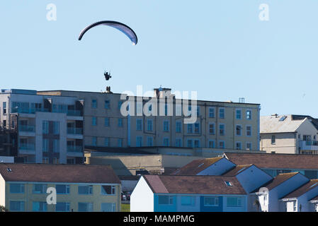 Un parapente voler au-dessus de bâtiments à Newquay Cornwall. Banque D'Images