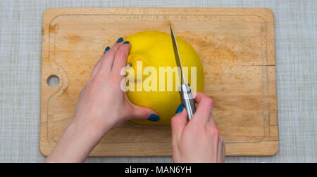 Girl cleaning ses mains avec agrumes pomelo, sur une planche en bois Banque D'Images