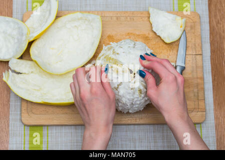 Girl cleaning ses mains avec agrumes pomelo, sur une planche en bois Banque D'Images