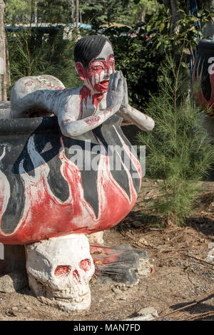 SUPHAN BURI, THAÏLANDE, JAN 01 2018, le pécheur dans l'enfer-chaudière, mendier avec ses mains jointes. Une scène de l'enfer Bouddhiste. Banque D'Images