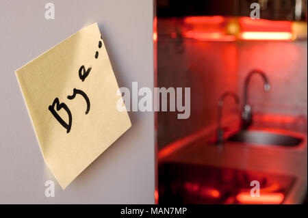 Fin de la relation concept : au revoir un note sur un réfrigérateur avec des appareils de cuisine et les feux rouges en arrière-plan flou Banque D'Images