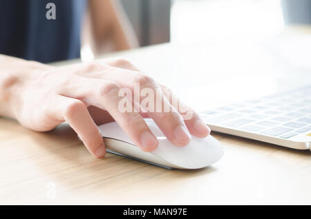Femme main tenant la souris tout en travaillant sur l'ordinateur Banque D'Images