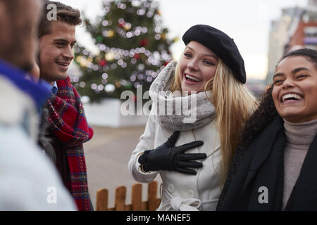 Les jeunes amis de marcher debout By Christmas Tree Banque D'Images