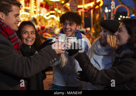 Groupe d'Amis de boire du vin chaud au marché de Noël Banque D'Images