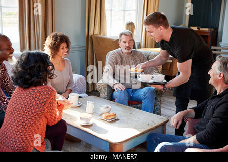 Waiter Serving Groupe d'amis d'âge mûr in Coffee Shop Banque D'Images