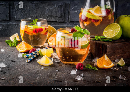 Summer cocktail glacé, fruits et baies de la sangria blanche avec de la pomme, citron, orange et framboise. arrière-plan sombre, copy space Banque D'Images