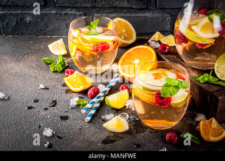 Summer cocktail glacé, fruits et baies de la sangria blanche avec de la pomme, citron, orange et framboise. arrière-plan sombre, copy space Banque D'Images