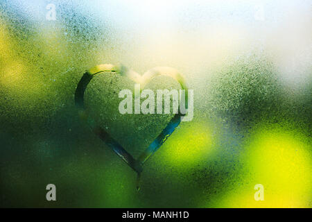 Gouttes d'eau de pluie et le printemps, l'inscription sur le verre en sueur - amour et coeur Banque D'Images