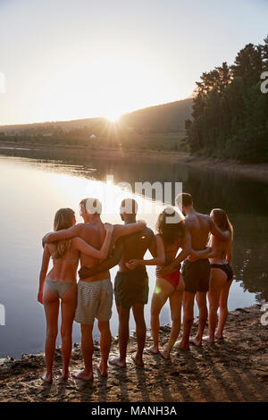 Young adult friends standing sur Lakeshore, vertical Banque D'Images