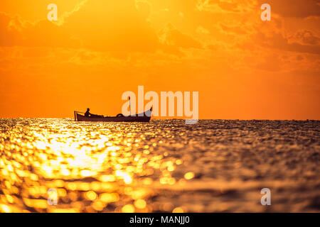 Voile pêcheur avec son bateau sur le magnifique lever du soleil sur la mer Banque D'Images