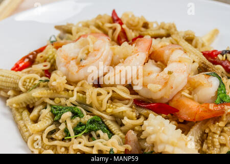 En crevettes poêlée de nouilles instantanées en plaque blanche sur table. Banque D'Images