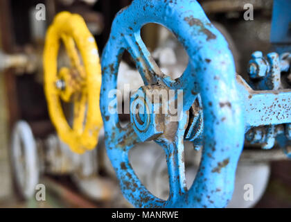 L'industrie et de vieux tuyaux. Rusty valve rotative et tuyaux dans une usine abandonnée. Banque D'Images