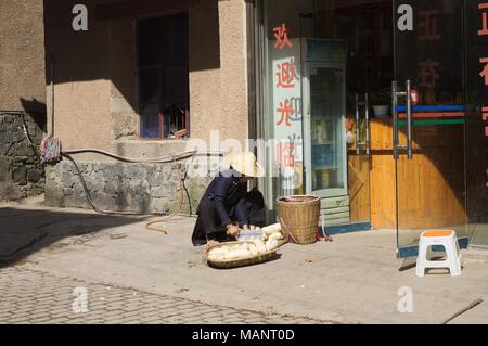 Duo Yi Shu Village, Yunnan, Chine - 26 décembre 2017 : vieille femme chinoise travaillant dans la rue Banque D'Images