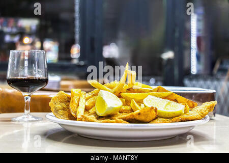 Une plaque d'Milanesas con papas fritas (schnitzel faite avec des pommes de terre frites et viande de vache) sur une table en bois dans un petit restaurant pour les travailleurs à Buenos Banque D'Images