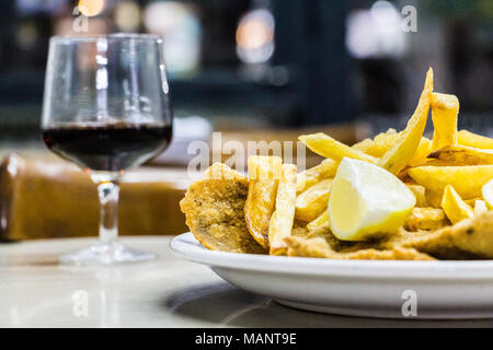 Une plaque d'Milanesas con papas fritas (schnitzel faite avec des pommes de terre frites et viande de vache) sur une table en bois dans un petit restaurant pour les travailleurs à Buenos Banque D'Images