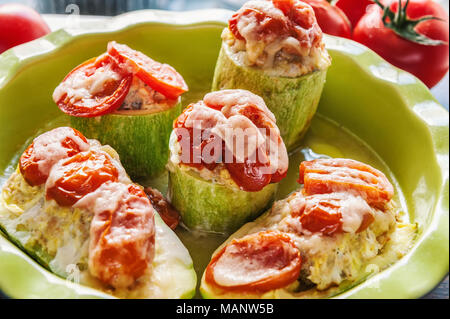 Morceaux de légumes courgettes farcies au riz avec tomates et fromage parmesan dans la nourriture végétarienne plat vert Banque D'Images