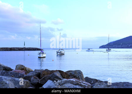 Port de plaisance dans la soirée avec de luxueux voiliers et bateaux à moteur à l'ancre. Scène Marina dans le coucher du soleil. Banque D'Images