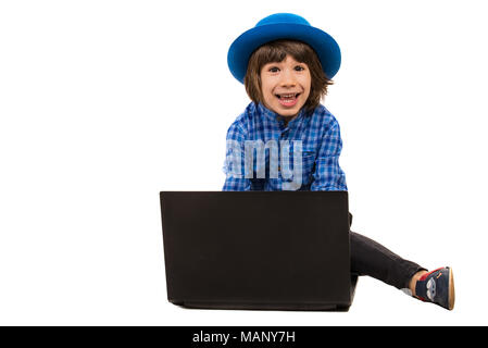 Surpris de la joyeuse petit garçon en face d'ordinateur portable isolé sur fond blanc Banque D'Images