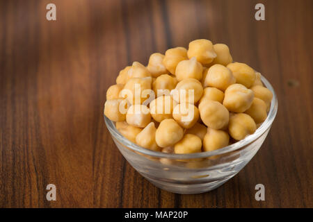 Grains de pois chiches (Cicer arietinum), dans le bol sur la table Banque D'Images
