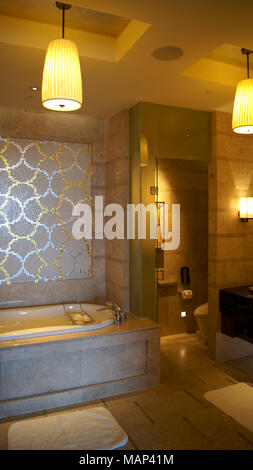 Singapour - 2 avr 2015 : grand et d'une salle de bains élégante dans des tons marron et beige, avec une baignoire en céramique dans un hôtel de luxe Banque D'Images