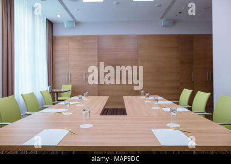 Il y a une salle de conférence avec un fer à cheval table et chaises confortables vert Banque D'Images